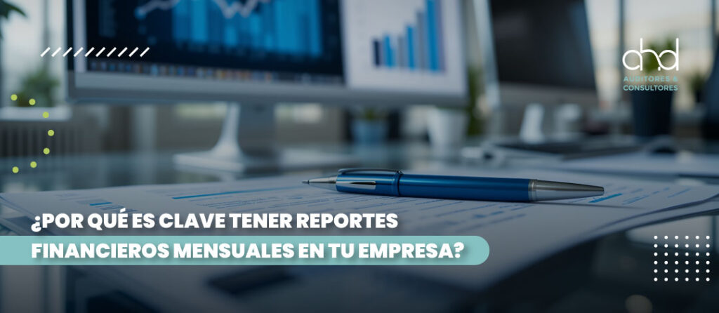 Escritorio con informes y gráficos financieros; importancia de reportes mensuales para la gestión de la empresa.